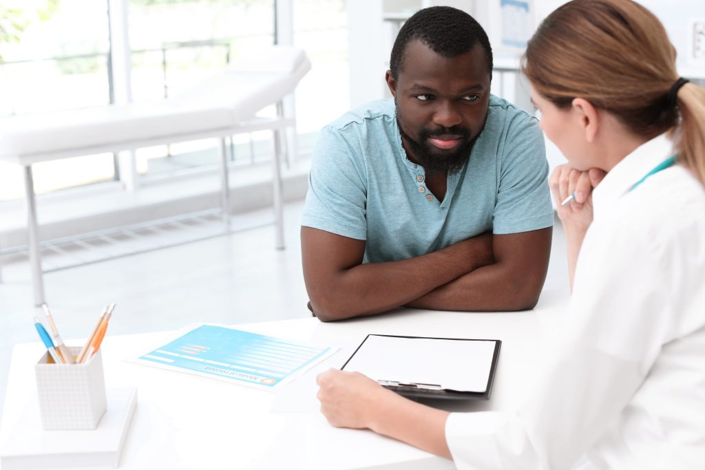 Young,Doctor,Speaking,To,African-american,Patient,In,Hospital