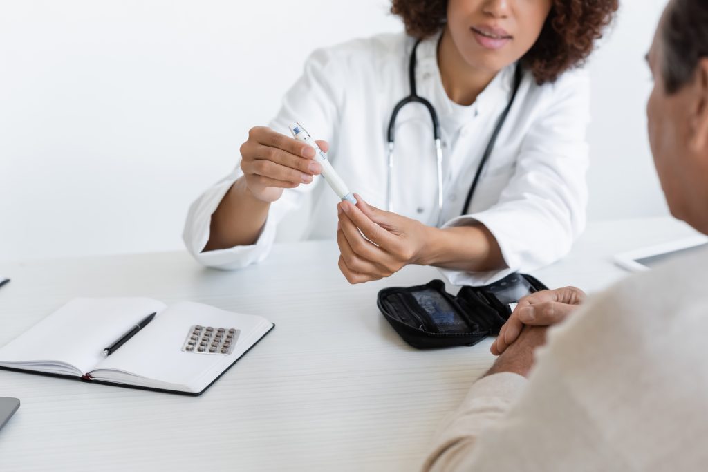 Cropped,View,Of,African,American,Doctor,Holding,Lancet,Pen,Near Cropped,View,Of,African,American,Doctor,Holding,Lancet,Pen,Near
