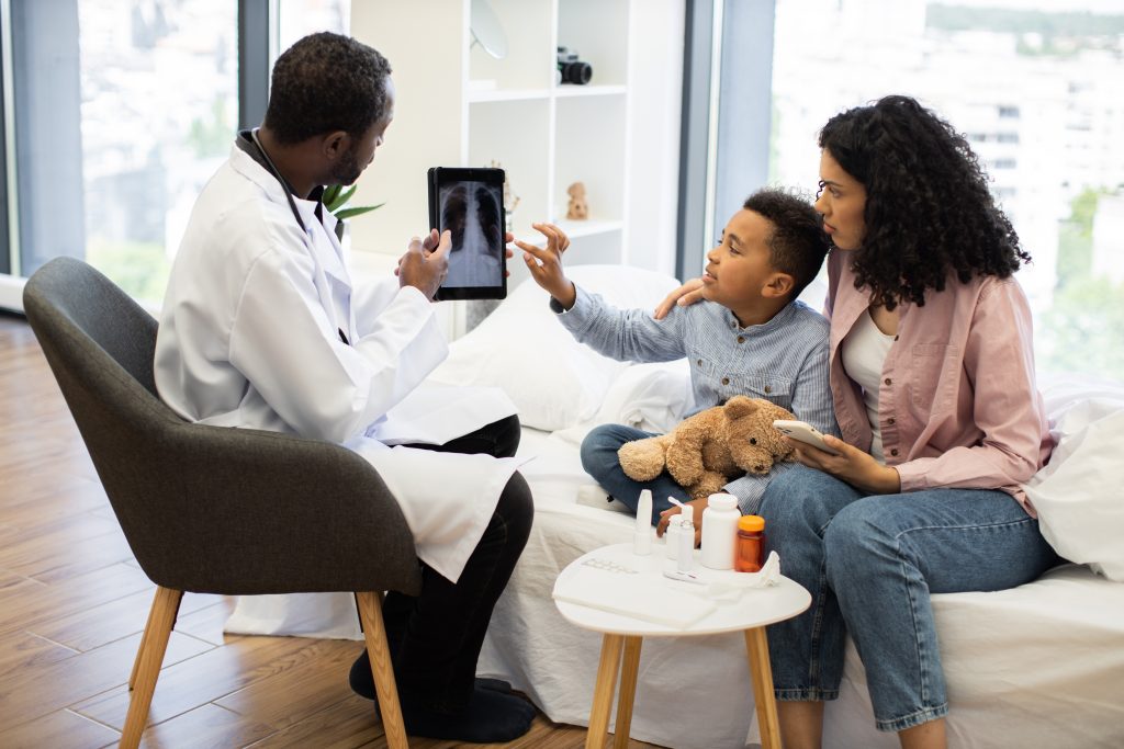 African,Doctor,Examines,X-ray,Image,On,Tablet,For,Young,African African,Doctor,Examines,X-ray,Image,On,Tablet,For,Young,African